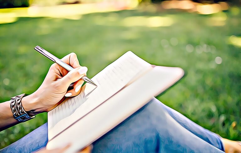 Person sitting on grass on a sunny day writing in a journal